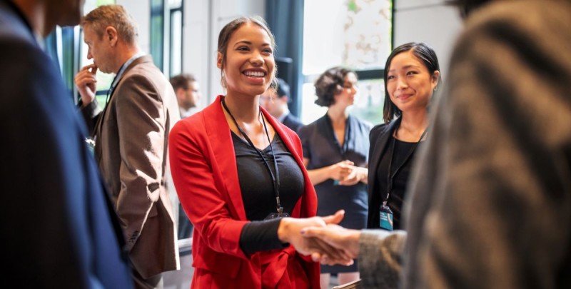 Woman in red suit shaking hands