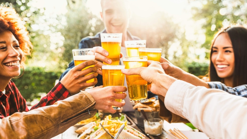 Group of people toasting with beers at brewery event